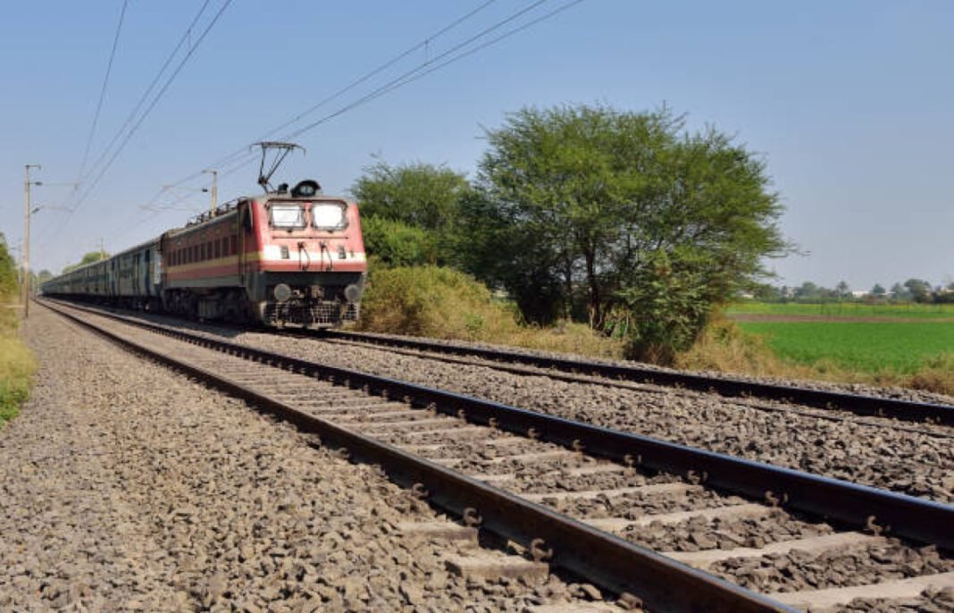 Indian long distance train passing near wheat field Indian Railways, Railway Budget 2024, infrastructure, technology, artificial intelligence, IoT, automation, innovative financing, project management, Union Budget, modernization, connectivity, freight demands,