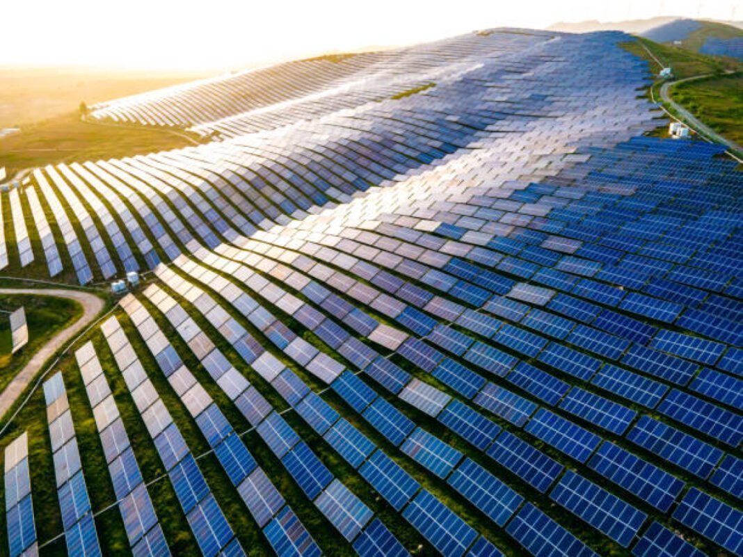 Aerial view of solar panels in mountain Adani Green Energy, TotalEnergies, solar joint venture, Khavda Gujarat, Power Purchase Agreements (PPAs), Solar Energy Corporation of India (SECI), green energy projects, sustainable energy, renewable energy transition, Indian renewable sector, energy infrastructure