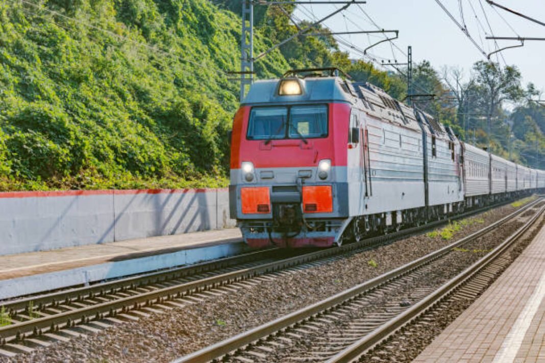 Passenger train moves along the platform by Black sea coast. Sochi. Russia. GPT Infra, South Eastern Railway, railway infrastructure, transportation modernisation, construction project, economic growth, infrastructure development, connectivity, transportation efficiency.
