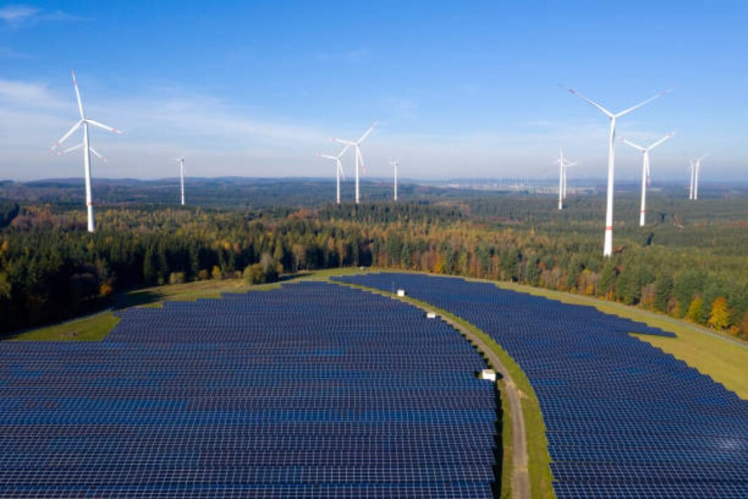 Aerial view of a solar and wind energy plant in a forest. Oriana Power, Rajasthan clean energy, solar energy, floating solar, green hydrogen, energy storage, Rising Rajasthan Global Summit 2024, renewable energy investments, sustainable energy